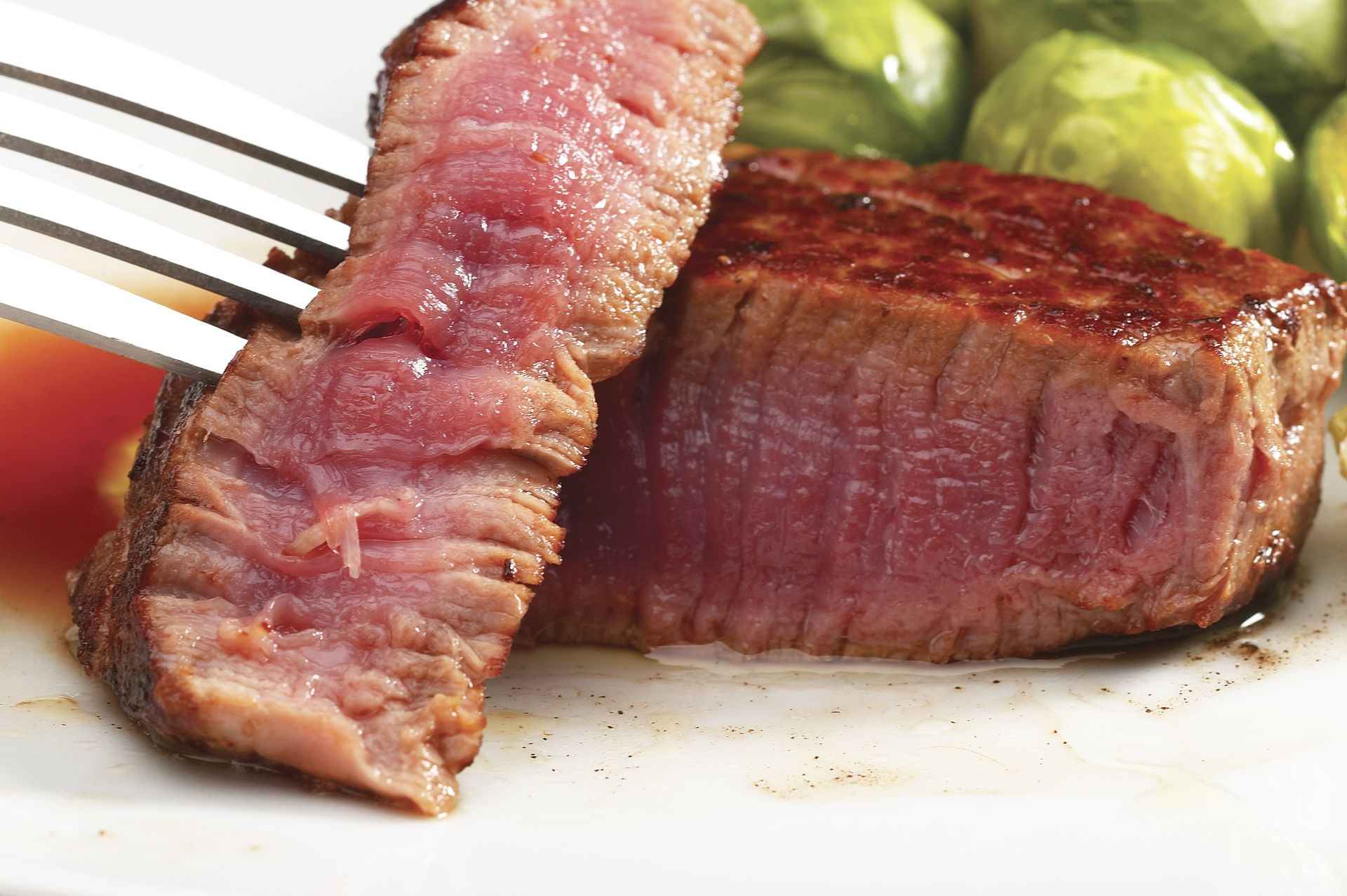 a piece of steak is being eaten with a fork