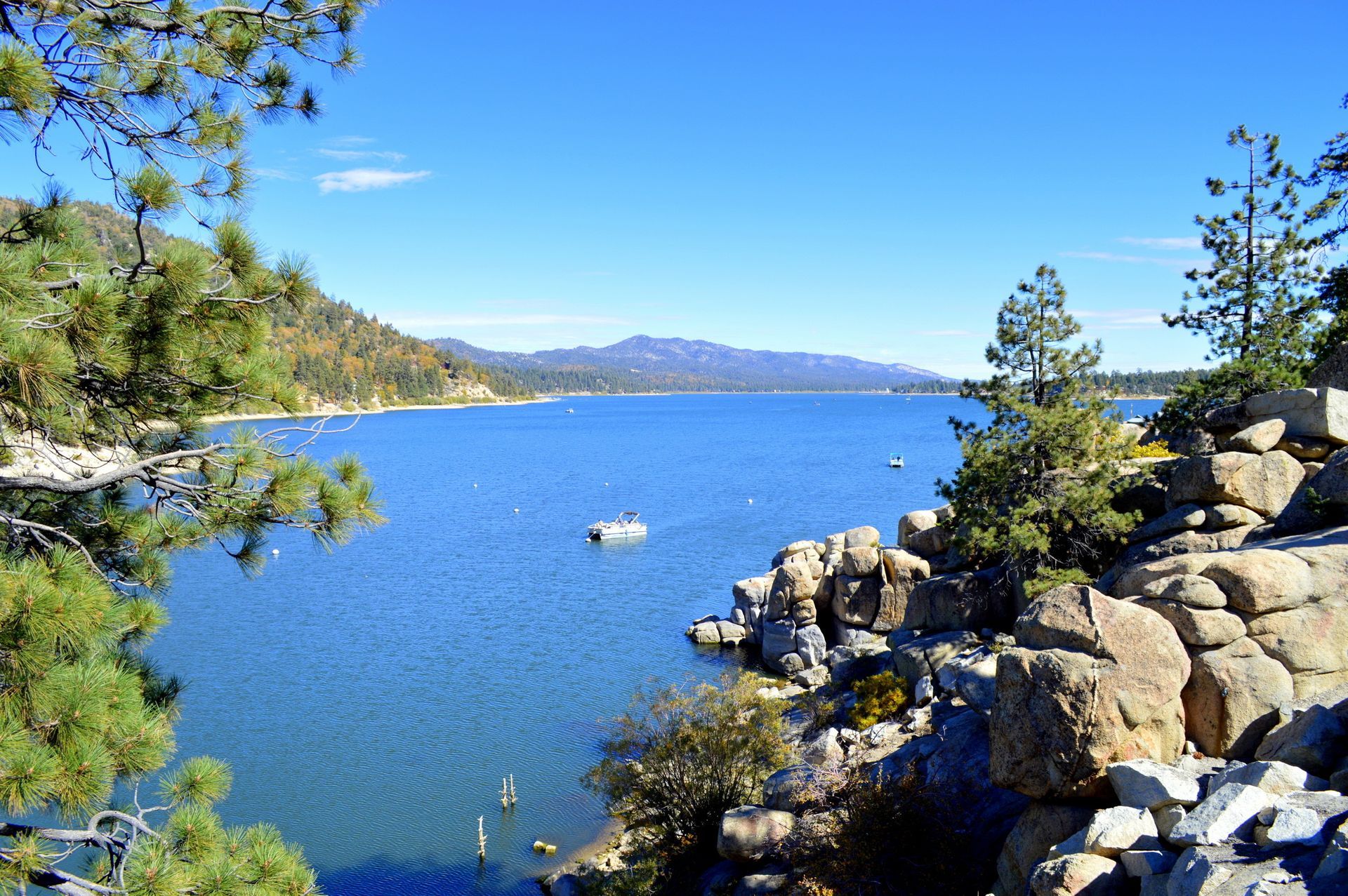 Big Bear lake surrounded by rocks and trees on a sunny day