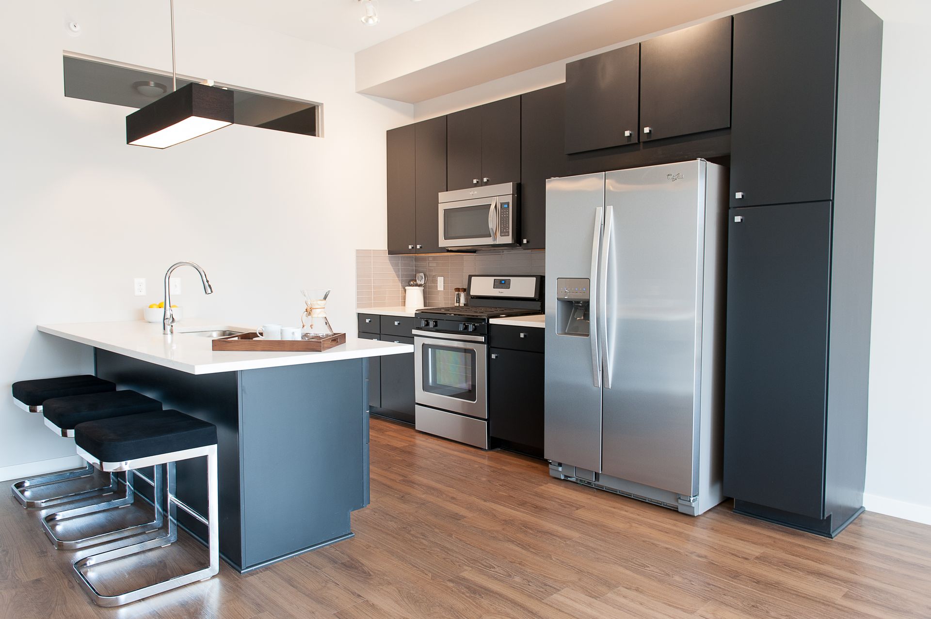 A kitchen with stainless steel appliances and black cabinets