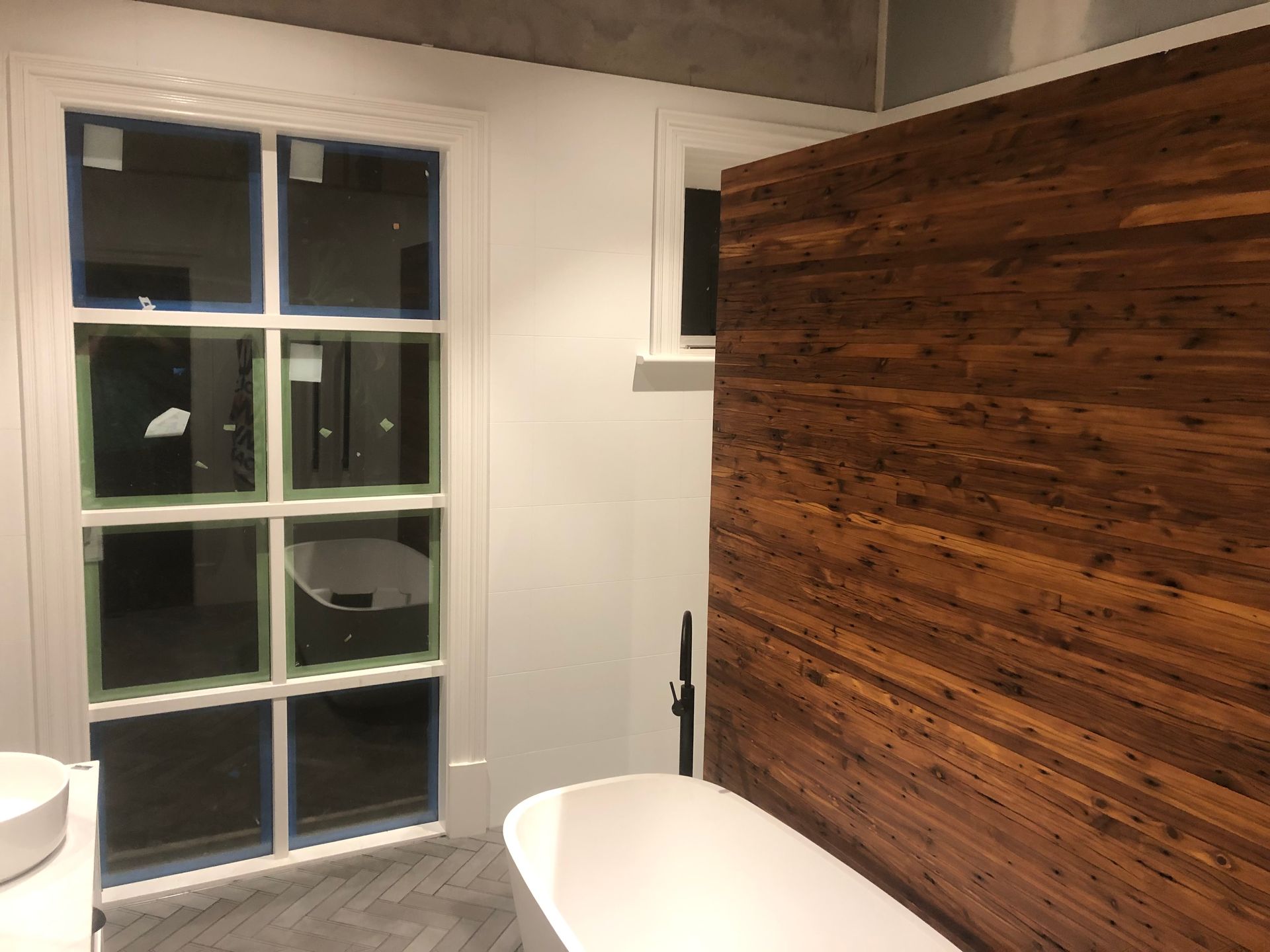 A bathroom with a wooden wall and a bathtub.