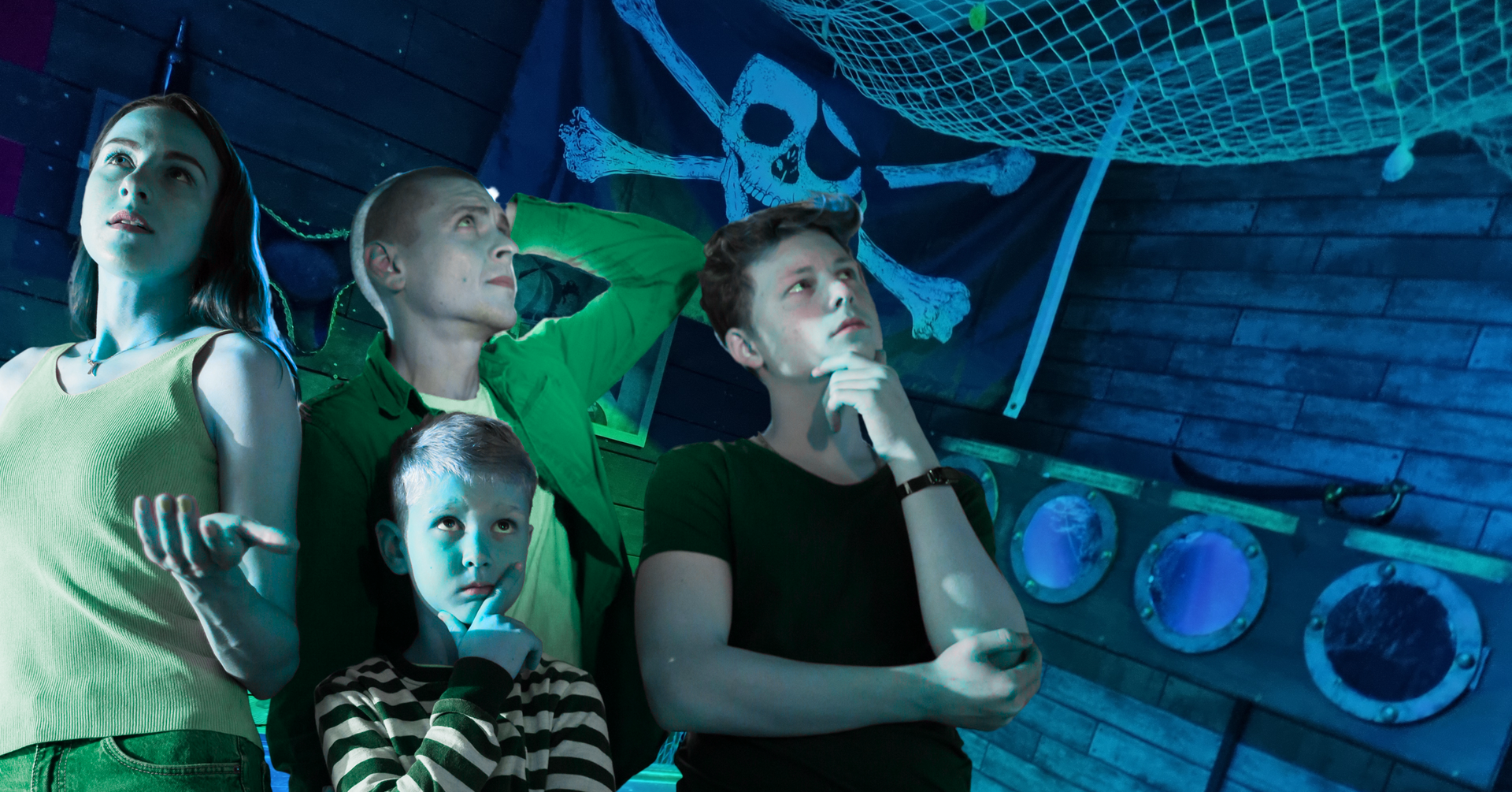 A group of people are standing in front of a pirate flag.