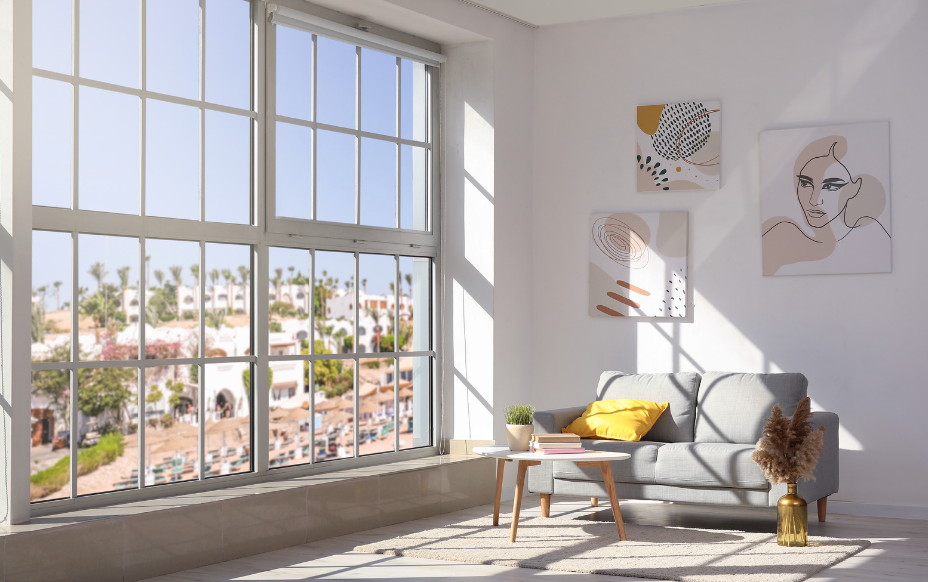 A living room with a couch , table , and large windows.
