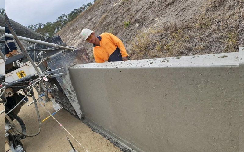 A man is cutting a concrete wall with a machine.