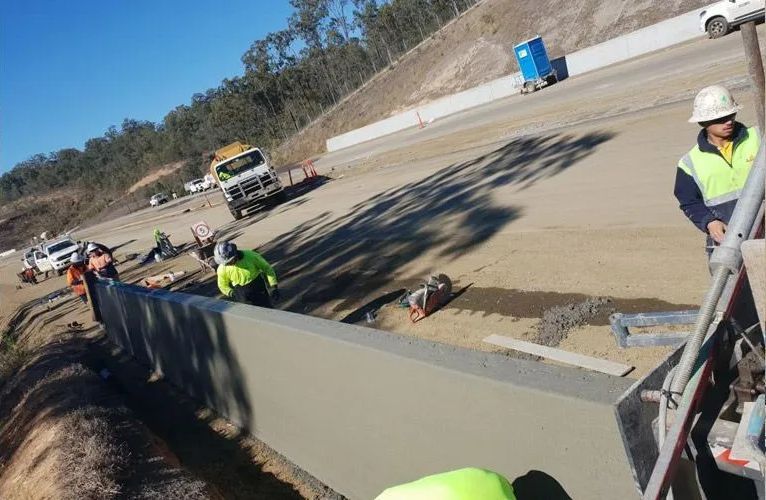 A group of construction workers are working on a road.