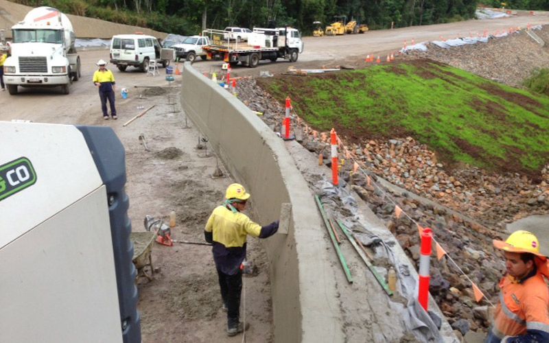 A concrete wall is being built on a construction site