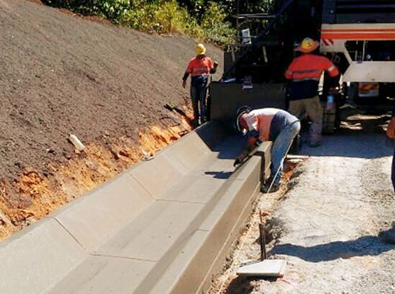 A group of construction workers are working on a road