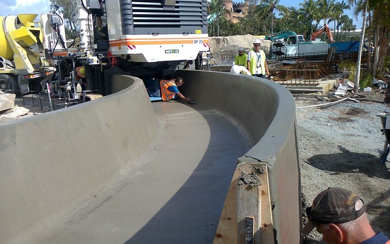 A man is standing next to a large concrete pipe.