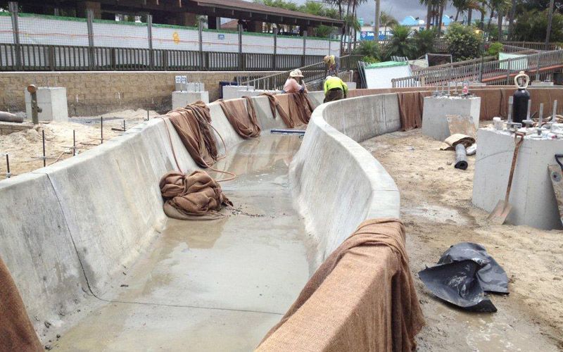 A large concrete wall is being built on a beach.