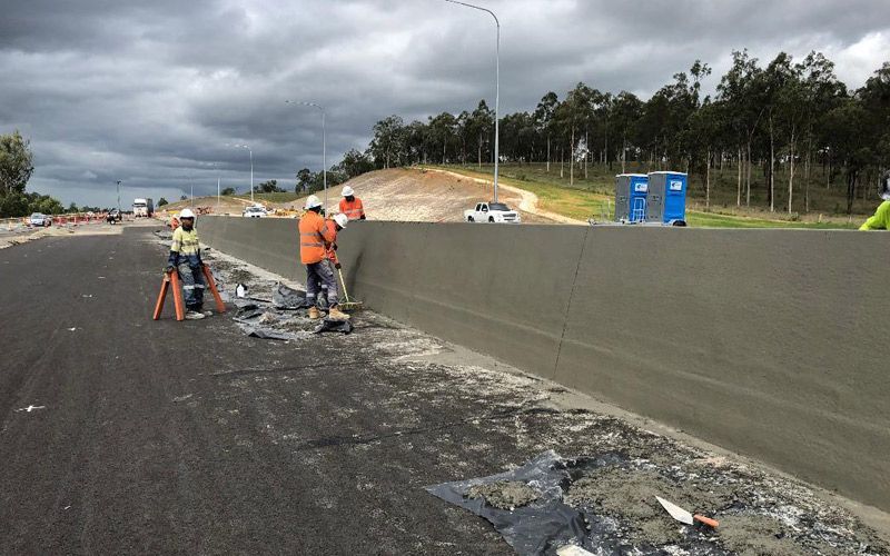 A group of construction workers are working on a highway.