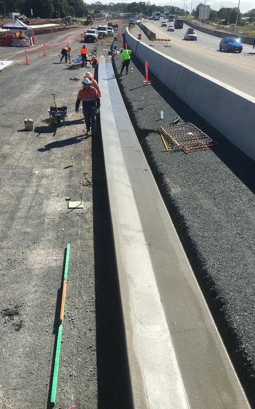 A group of construction workers are working on a highway.