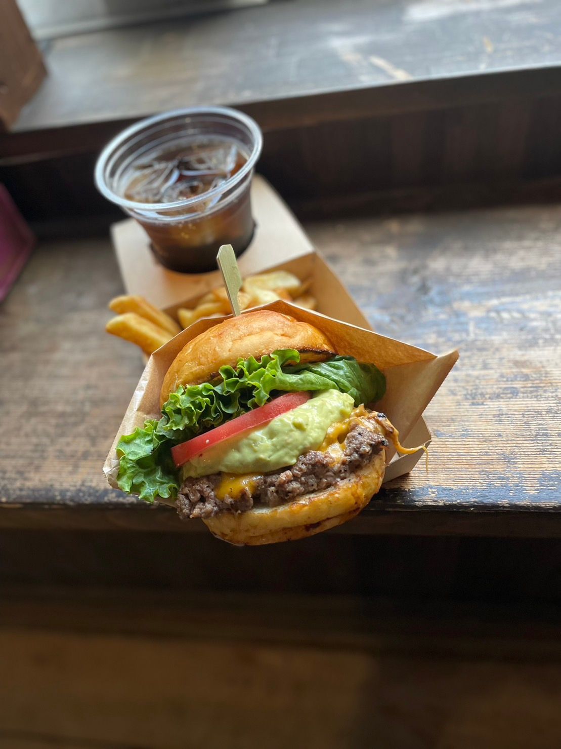 ハンバーガーとフライドポテトが木のテーブルの上にあります。