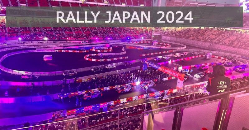 Rally Japan 2024: Cars racing on a stadium track with crowds in the stands.