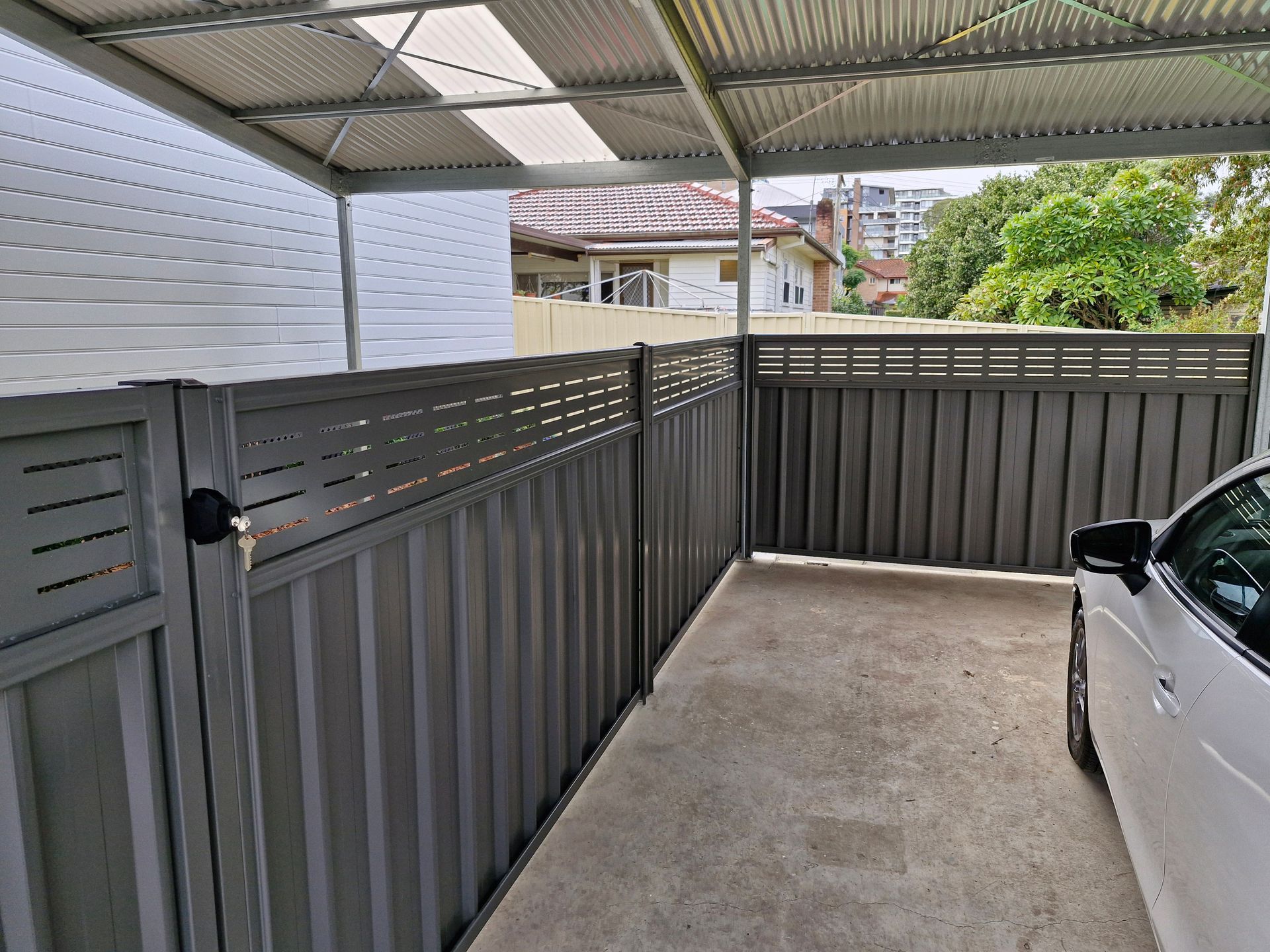 Grey Fenced Carport With a Parked Car — Strike Fencing & Gates In Tuggerah, NSW