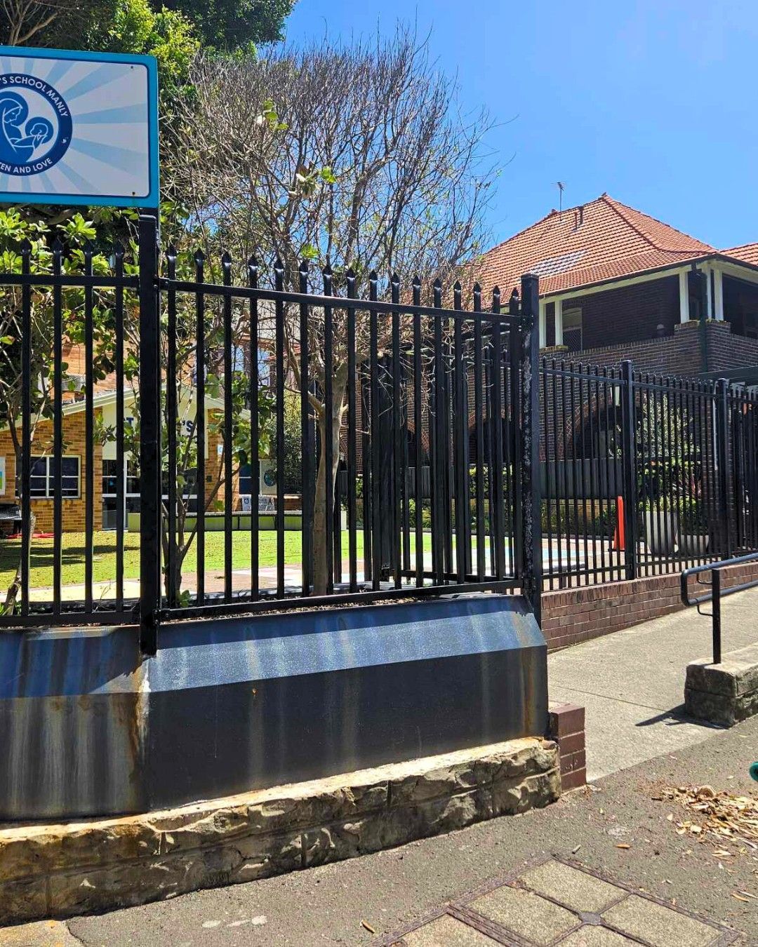 Black Metal Fence in Front of a School Building — Strike Fencing & Gates In Tuggerah, NSW