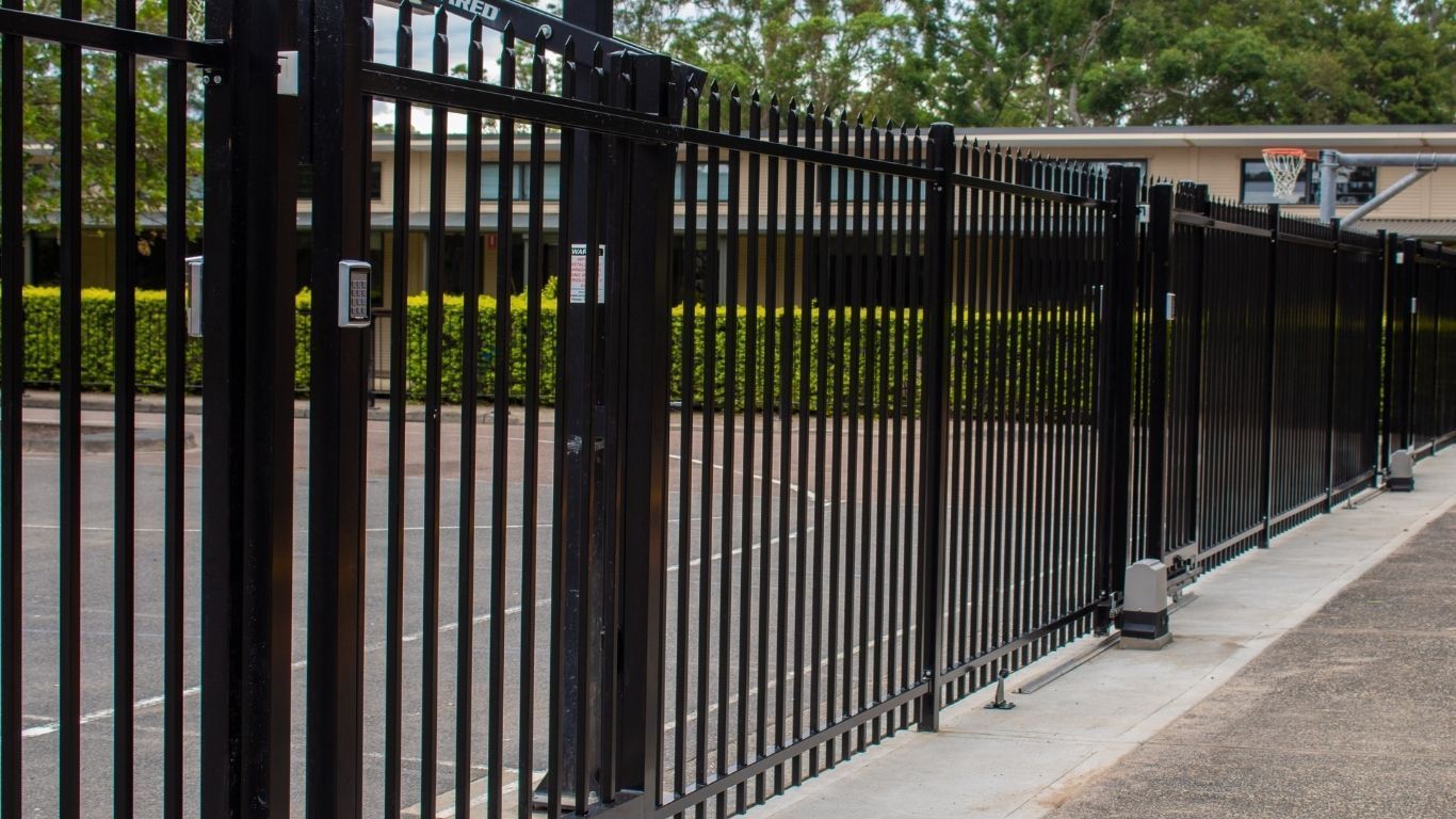 Black Metal Gate, Open on Paved Road — Strike Fencing & Gates In Tuggerah, NSW