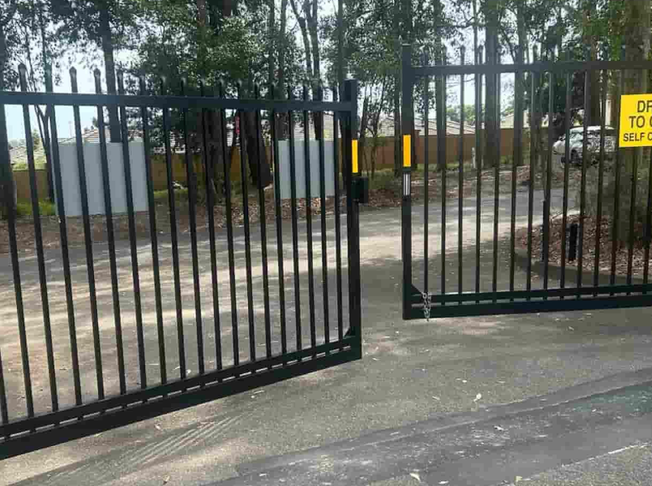 Black Metal Gate, Open on Paved Road — Strike Fencing & Gates In Tuggerah, NSW