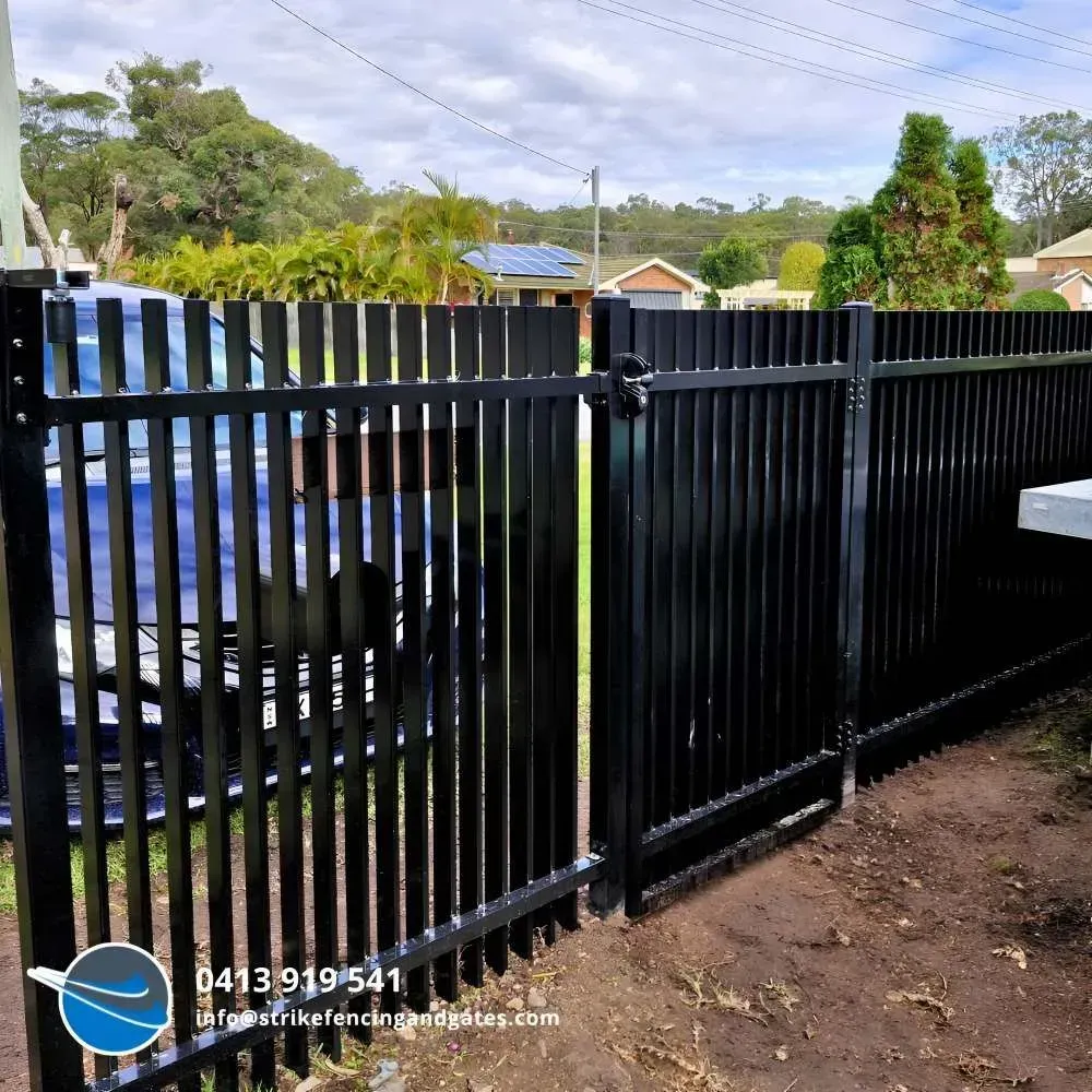 Black Metal Fence in Front of a Blue Car — Strike Fencing & Gates In Killarney, NSW