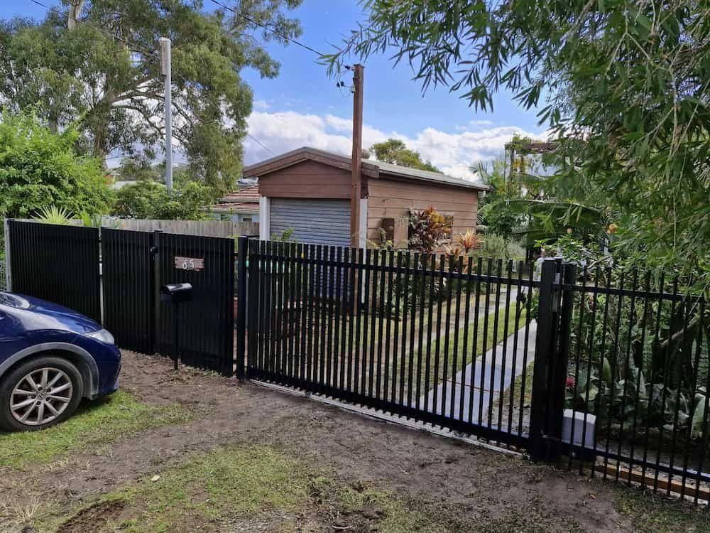 Black Metal Fence and Gate in Front of a House With a Garage — Strike Fencing & Gates In Tuggerah, NSW