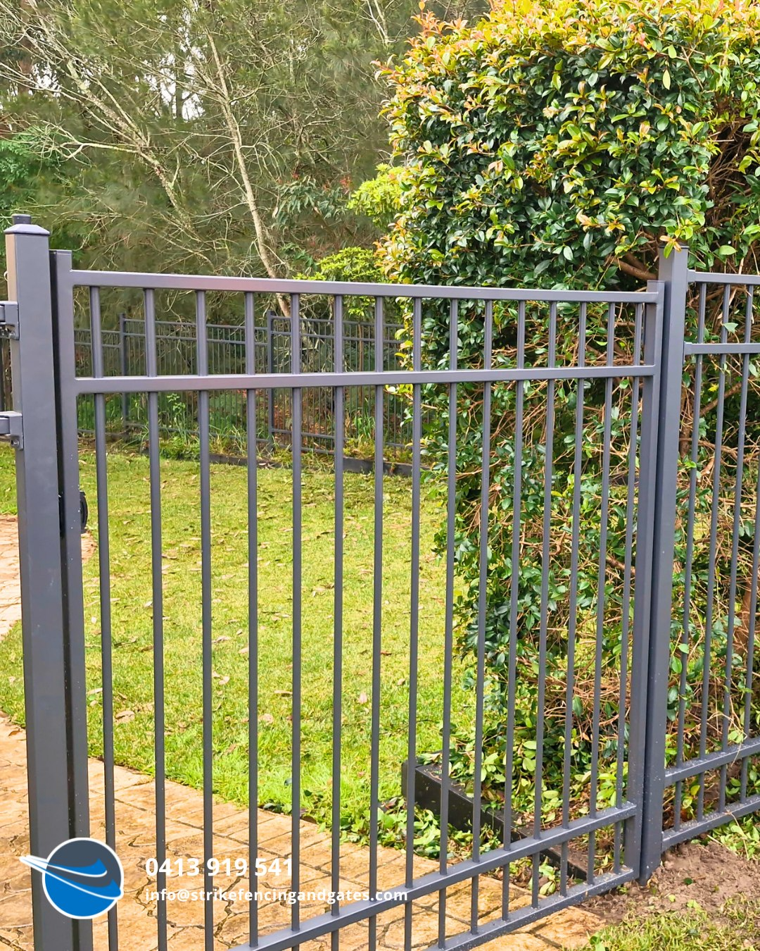 Dark Grey Metal Fence in Front of a Green Lawn and Bush — Strike Fencing & Gates In Woy Woy, NSW
