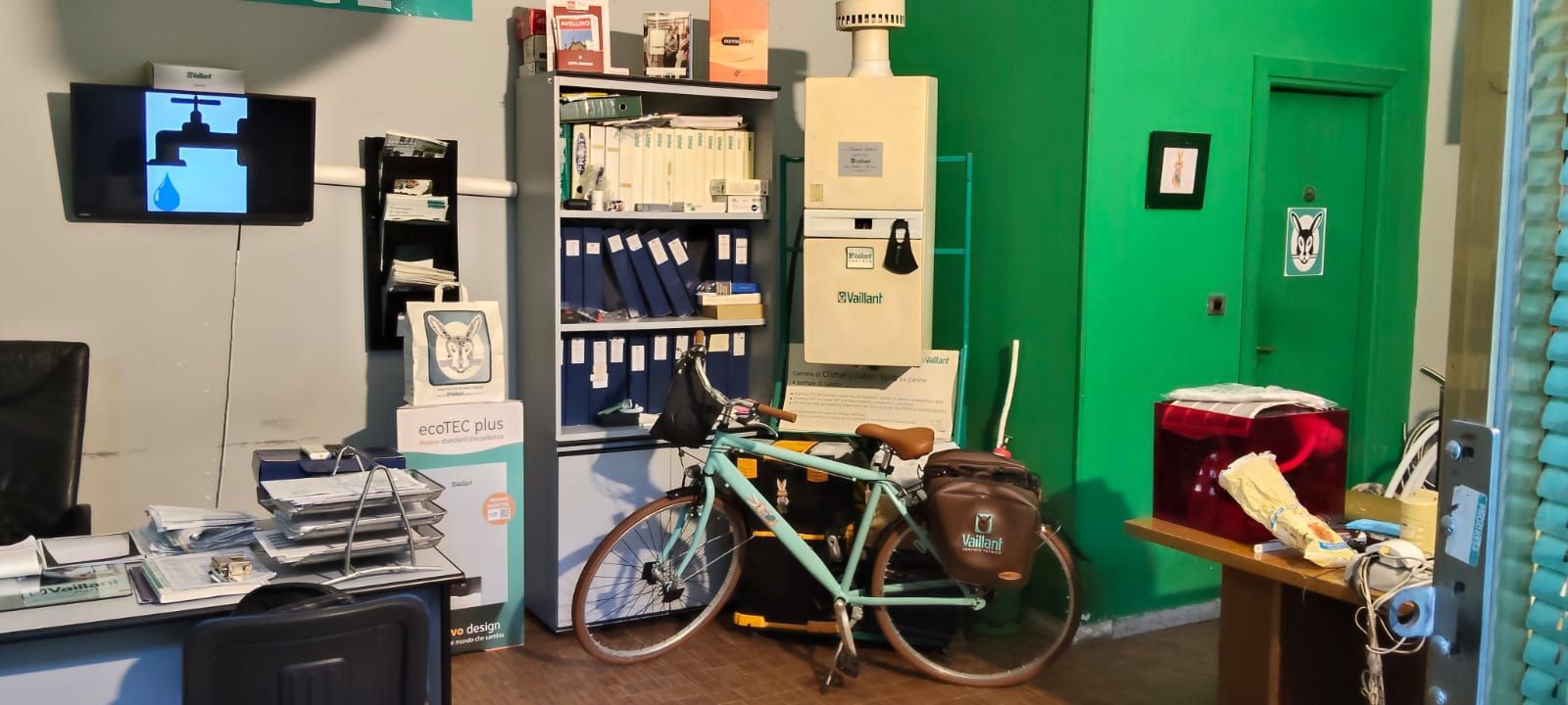 Una bicicletta è parcheggiata in una stanza con una parete verde
