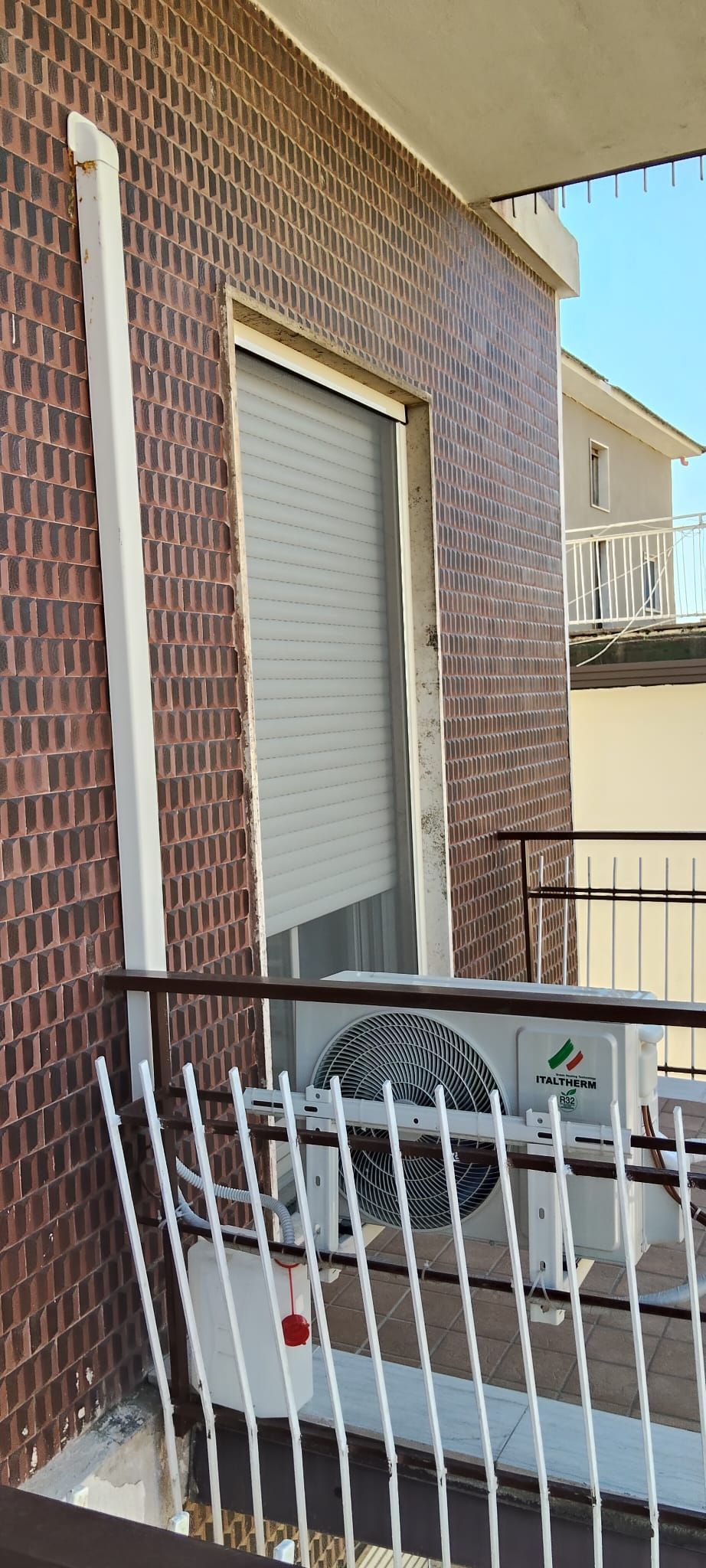 Un edificio in mattoni con un balcone e una finestra