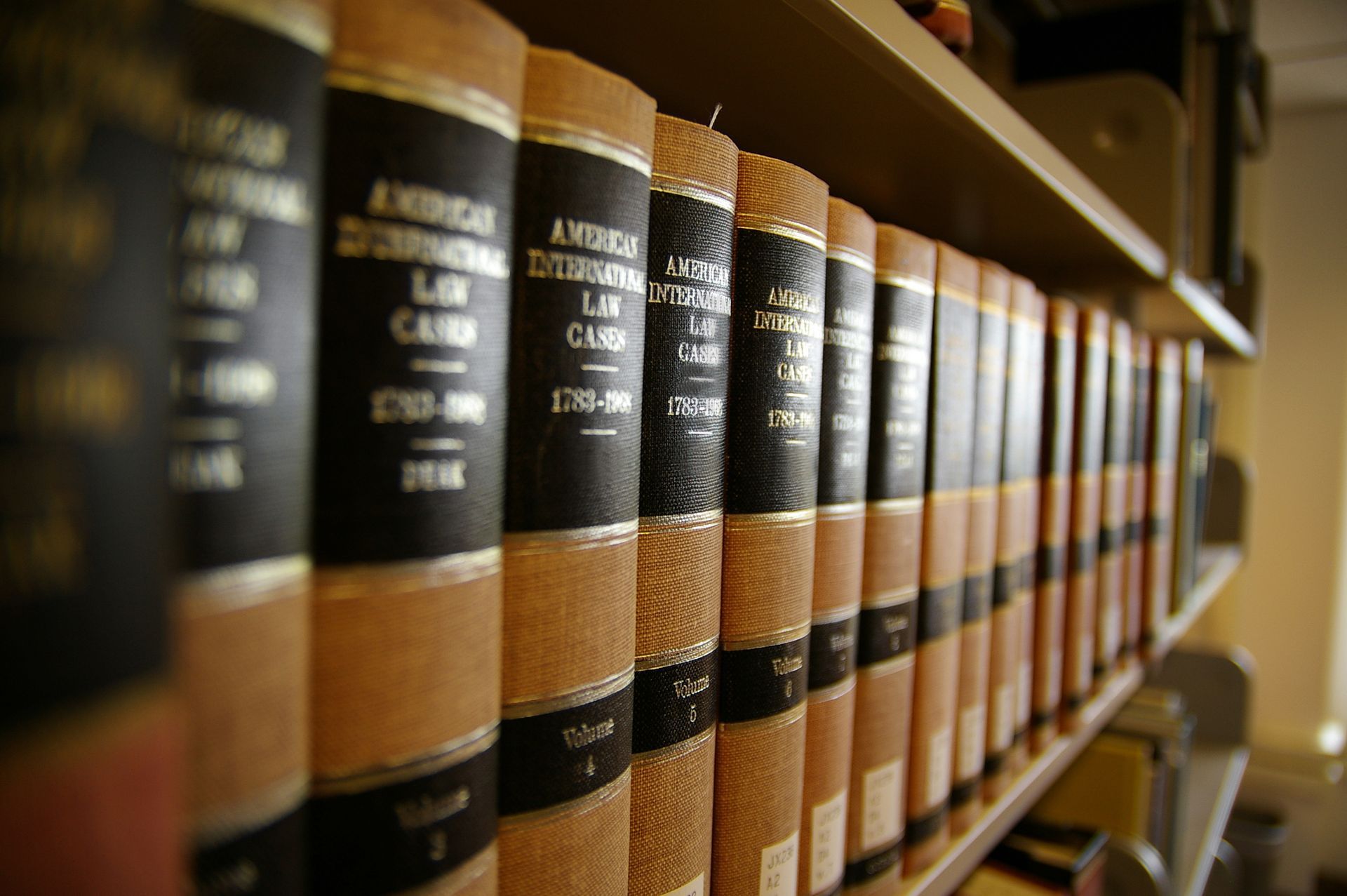 A row of vintage leather-bound law books lined up on a library shelf.