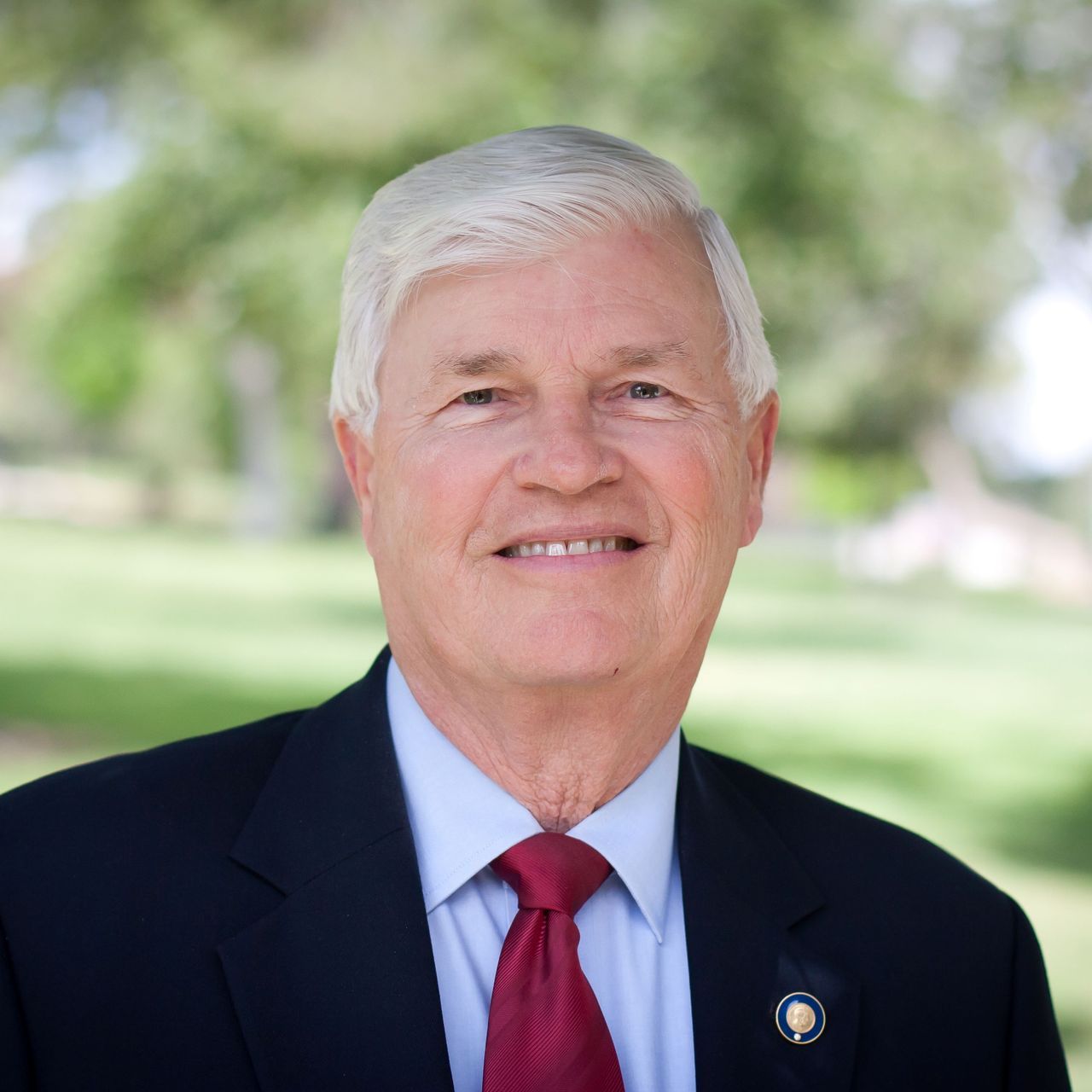 A man in a suit and tie is smiling for the camera