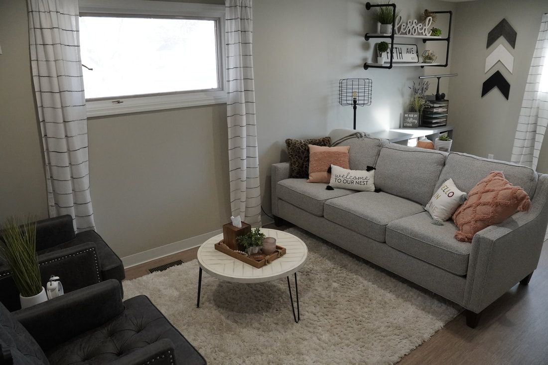 A living room with a couch , chairs , and a coffee table.