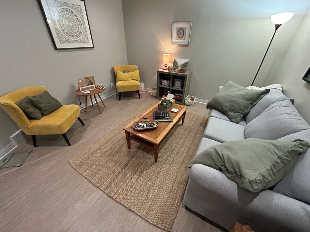 A living room with a couch , chairs , and a coffee table.