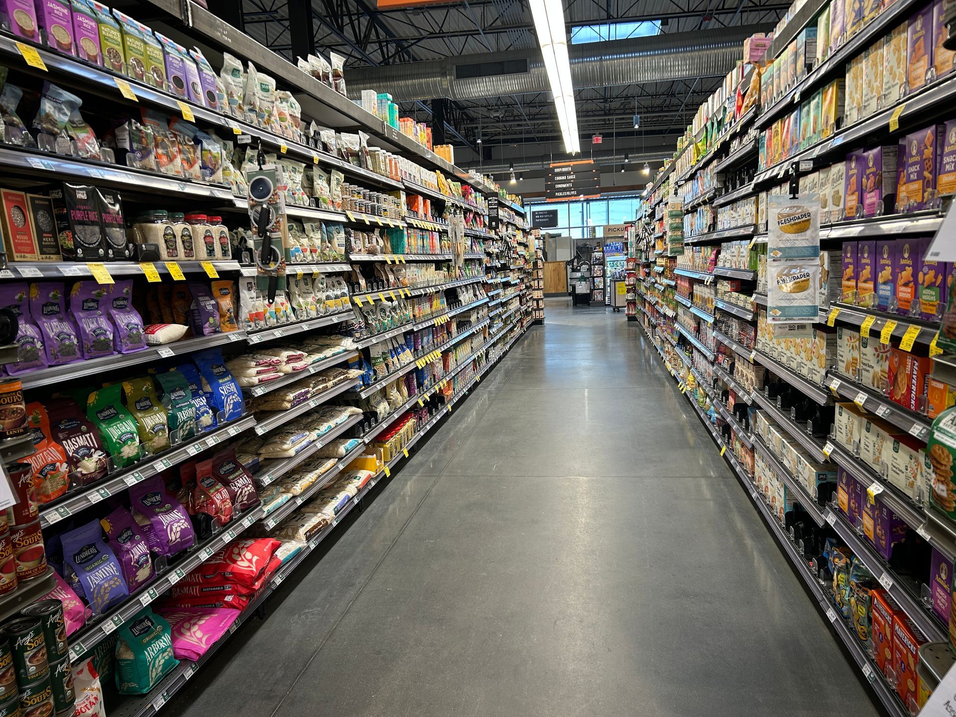 A long aisle of a grocery store filled with lots of products
