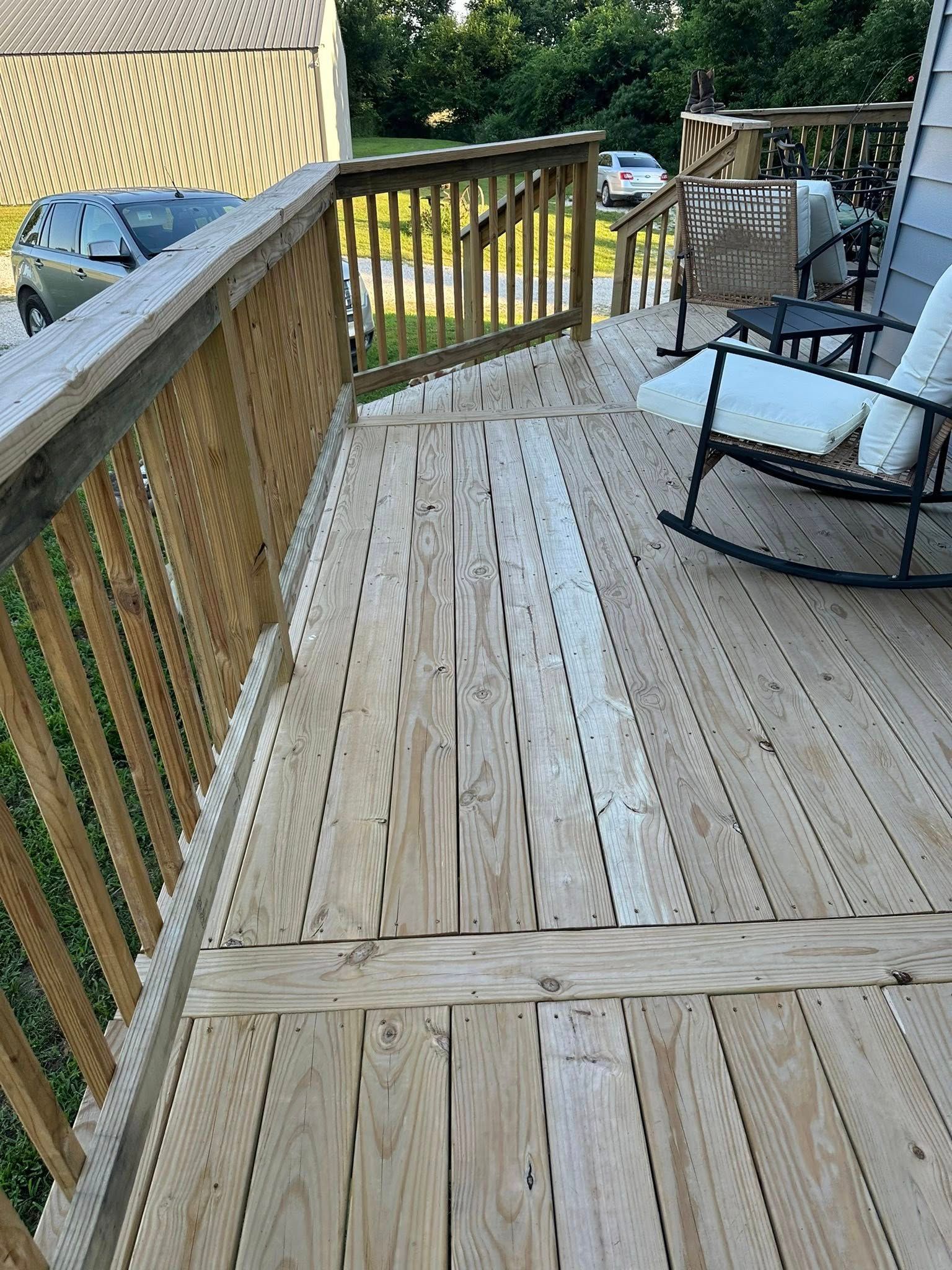 Wooden deck with railings, weathered planks, and a rocking chair.
