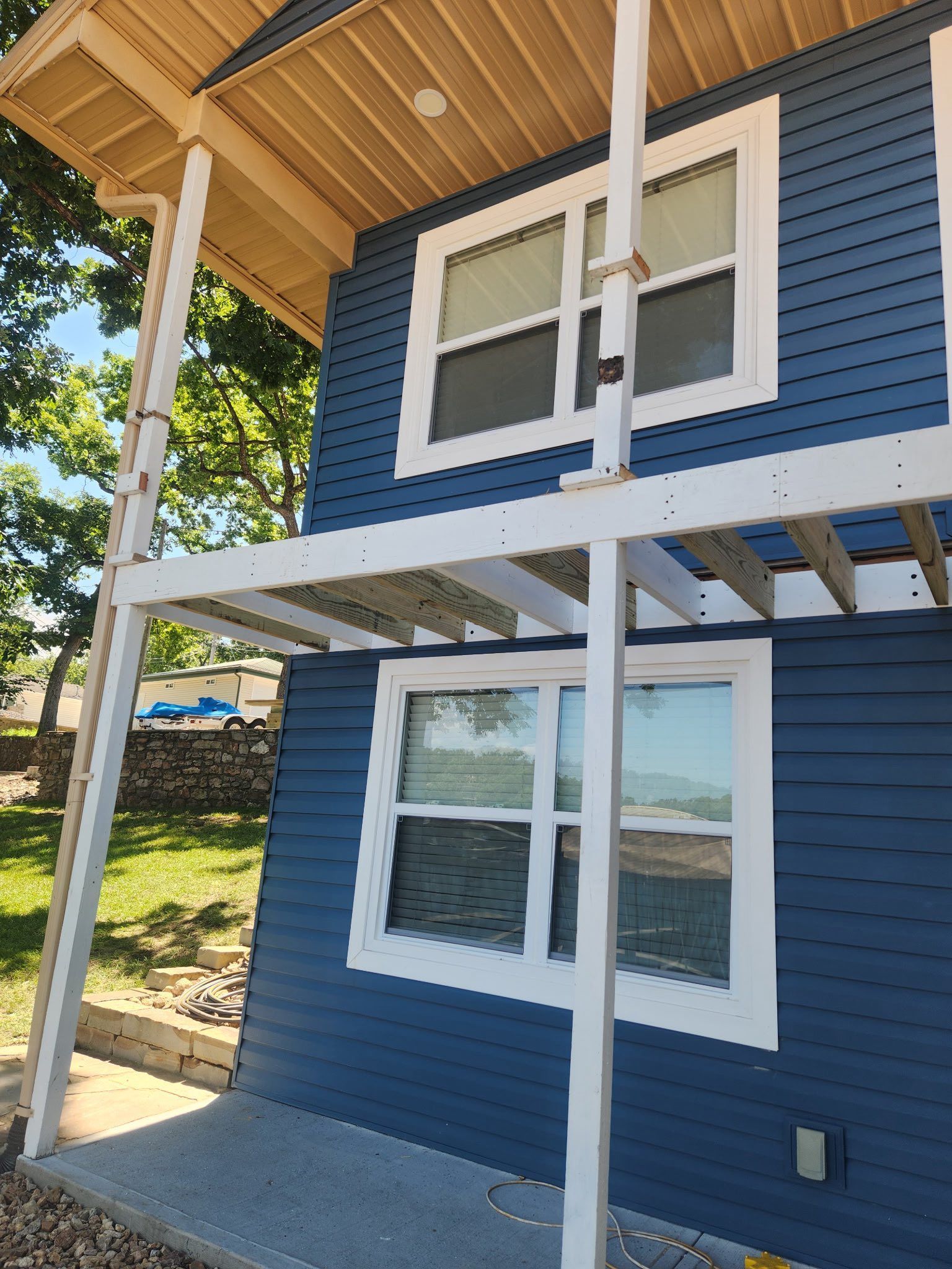 Blue house with white trim and a small porch; sunny day.