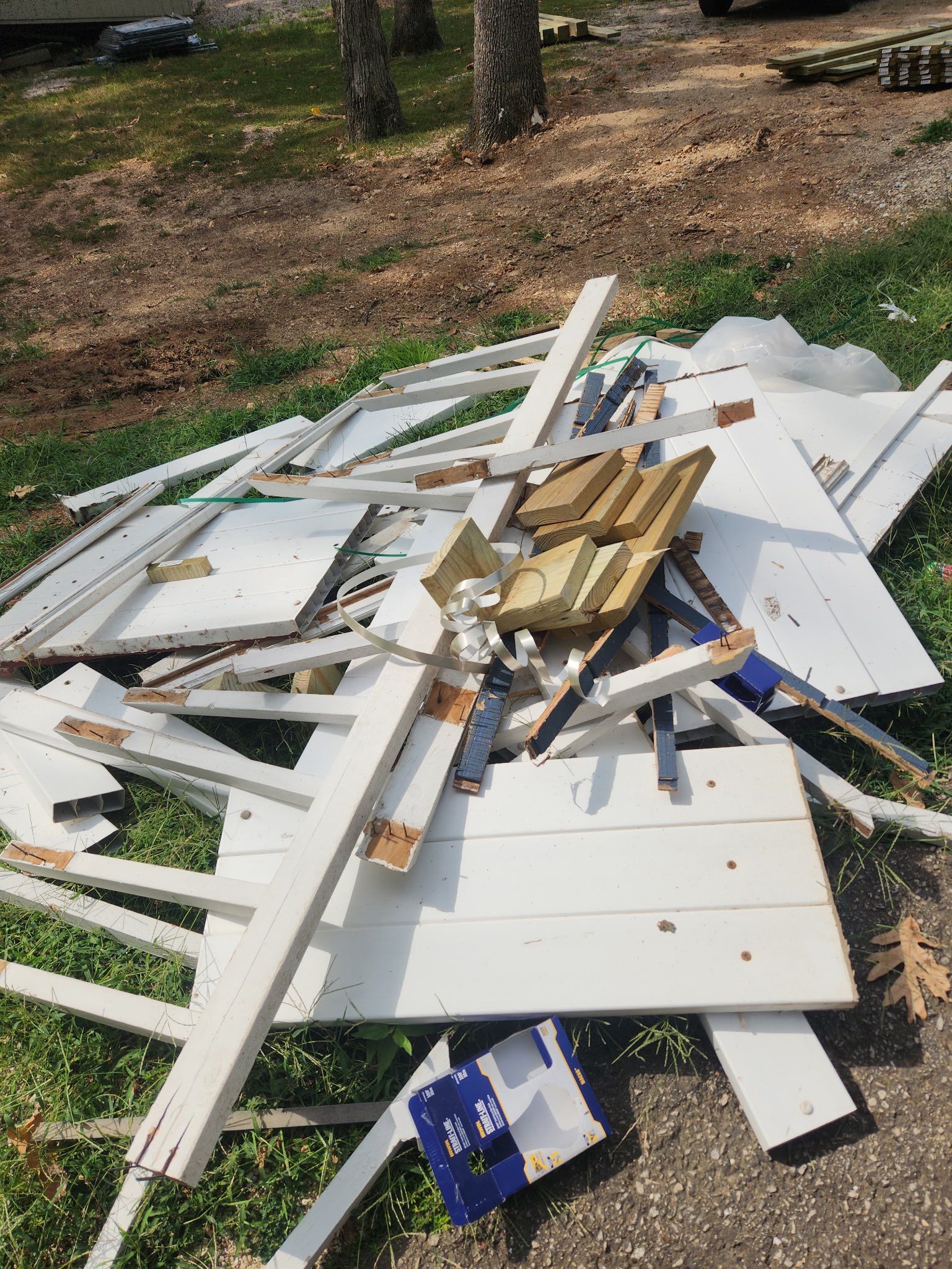 Pile of discarded white painted wood debris on the ground.