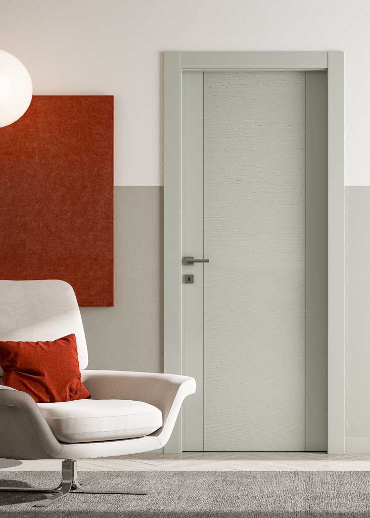 soggiorno con una poltrona bianca e una porta bianca
