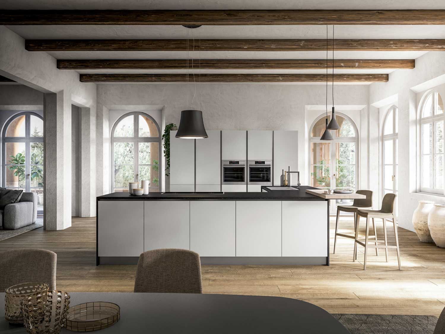 cucina con mobili bianchi e ripiano centrale nero.