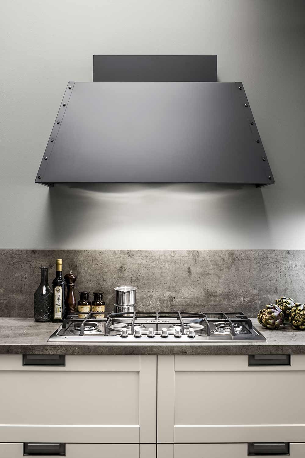 una cucina con forno e cappa sopra.