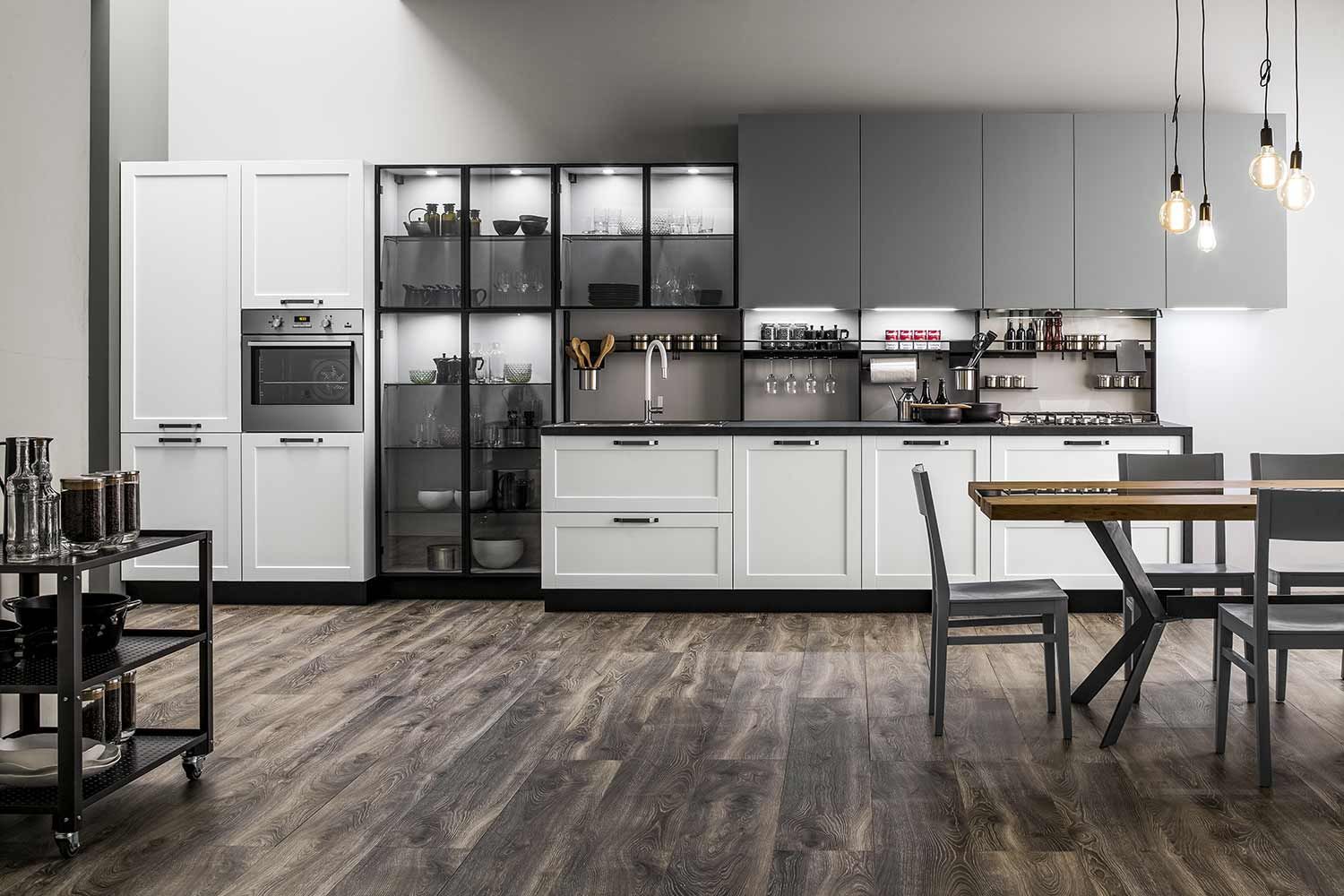 cucina con mobili bianchi, tavolo e sedie.