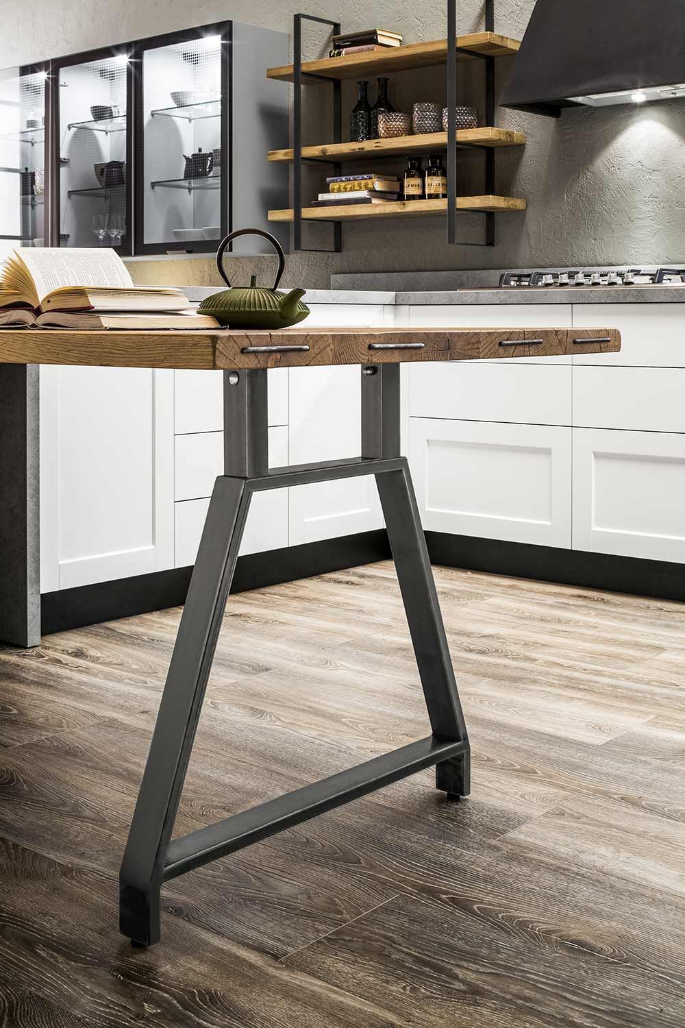 cucina con mobili bianchi e un tavolo di legno con sopra una teiera.