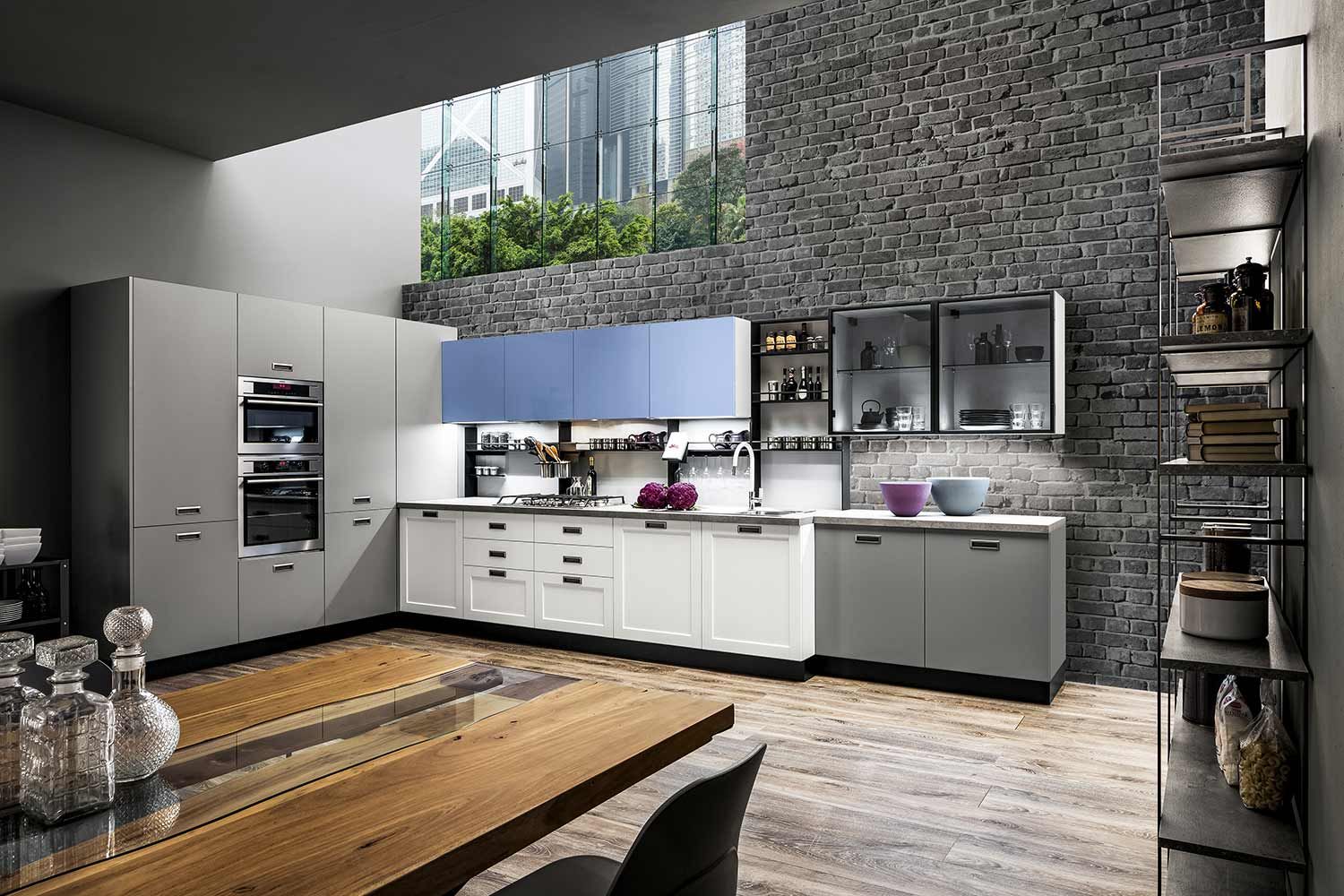 una cucina con tavolo e sedie in legno e parete in mattoni.