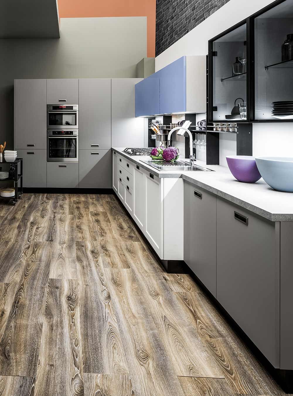 cucina con pavimento in legno e mobili bianchi