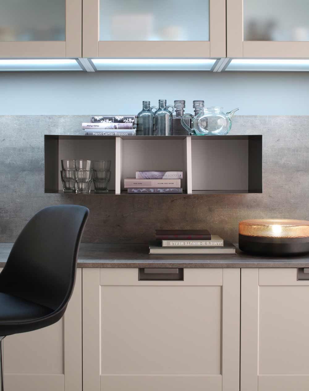 cucina con mobili bianchi e una sedia nera