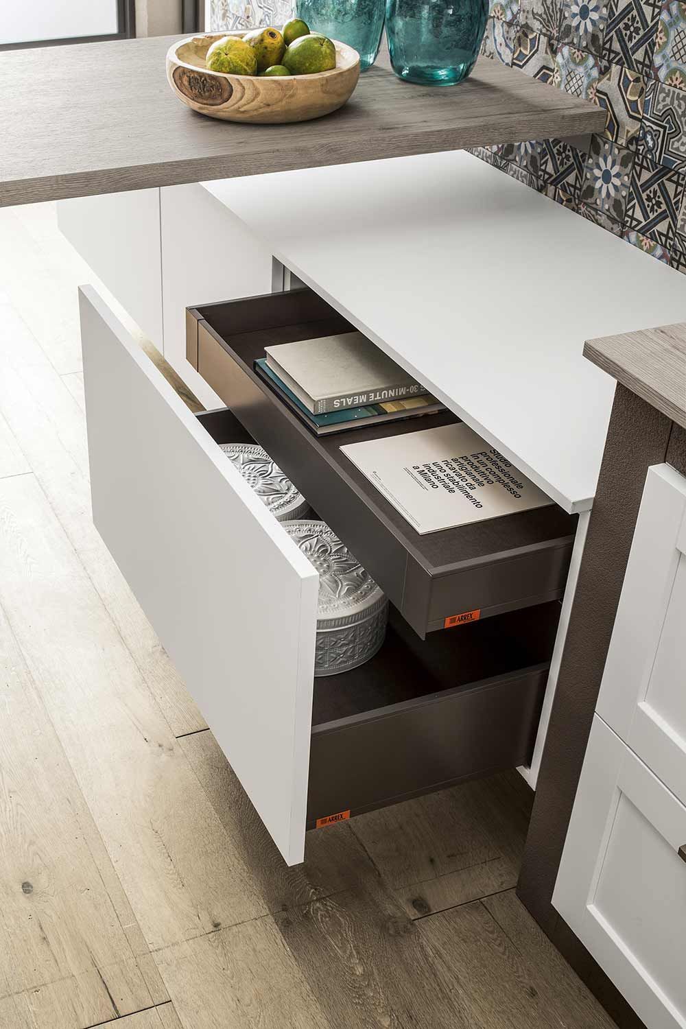 cucina con un cassetto aperto e un cesto di frutta sul ripiano.