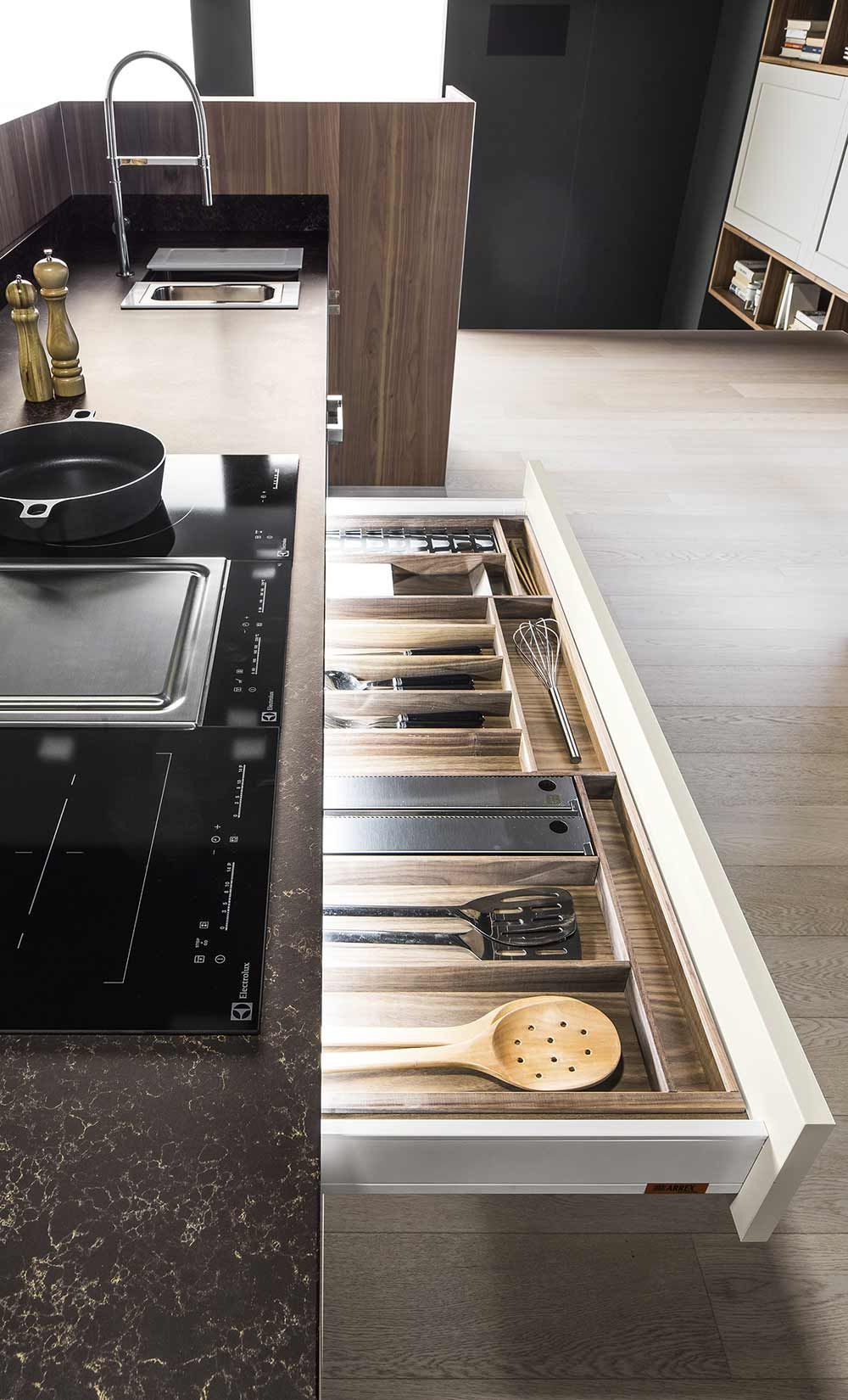 Una cucina con un cassetto pieno di utensili in legno