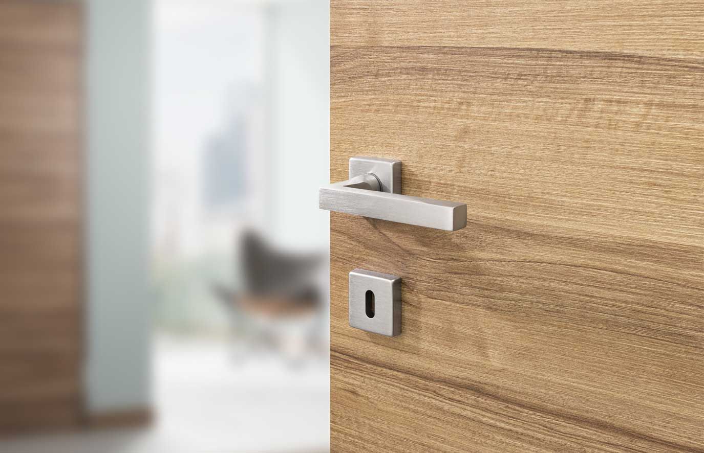 primo piano di una porta in legno con maniglia in acciaio inossidabile