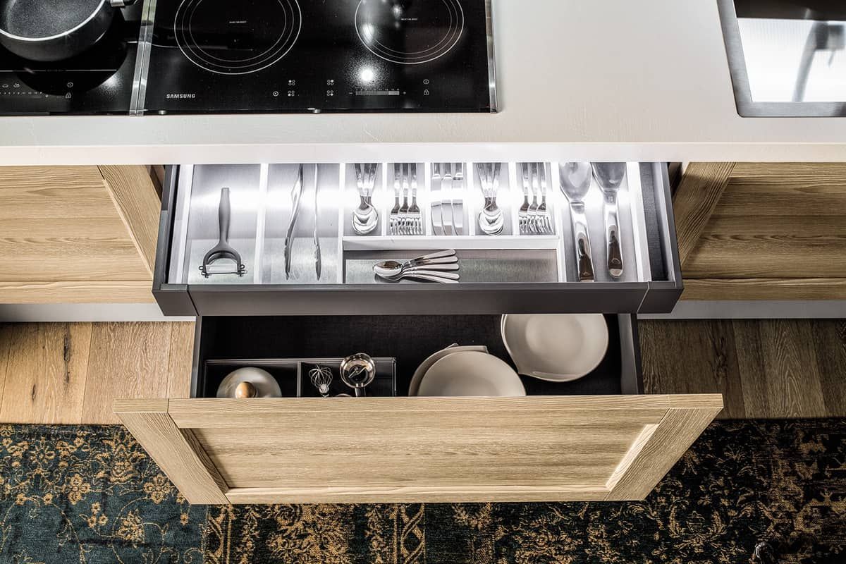 cucina con un cassetto pieno di utensili e piatti.