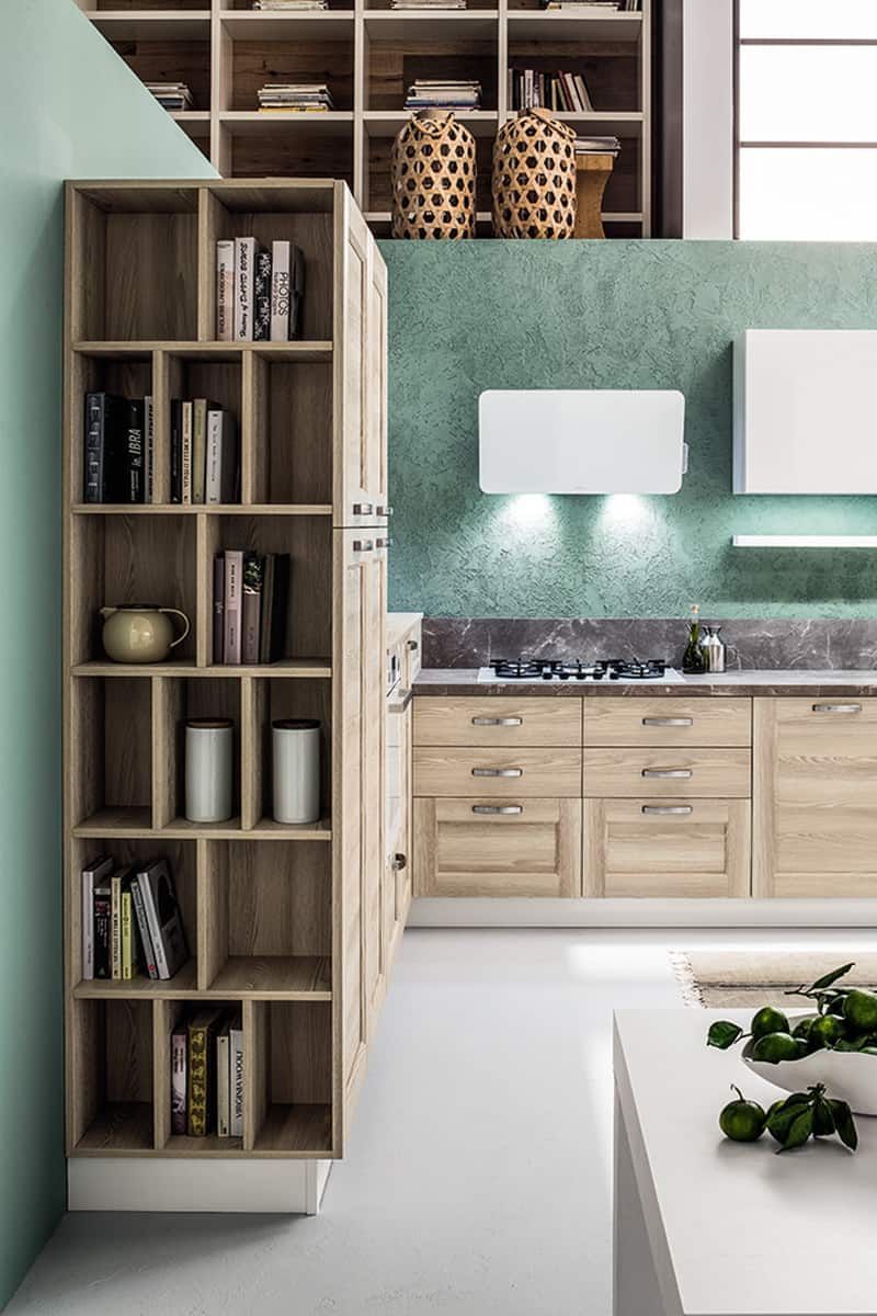 cucina con mobili in legno vicino a uno scaffale con libri