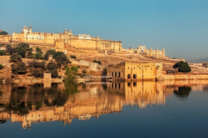 A castle is reflected in the water of a lake.