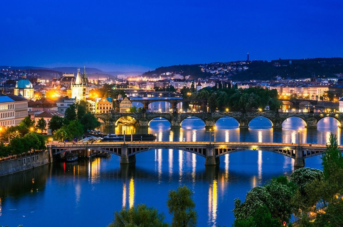 A bridge over a river in a city at night.