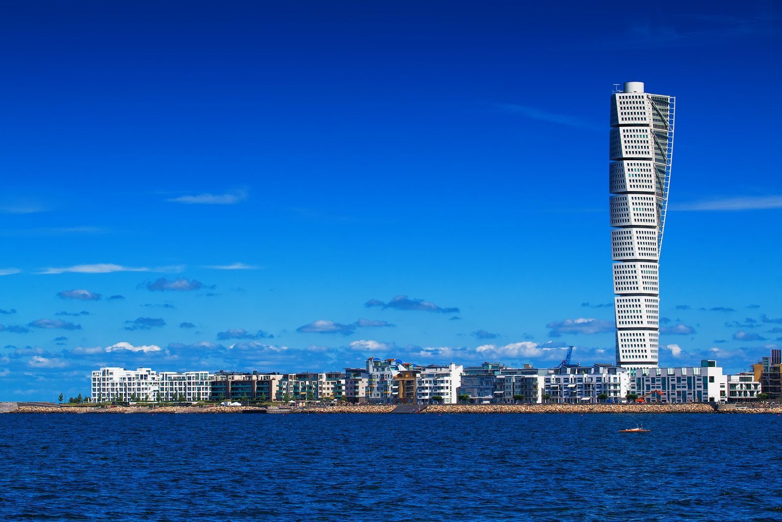A very tall building in the middle of a body of water