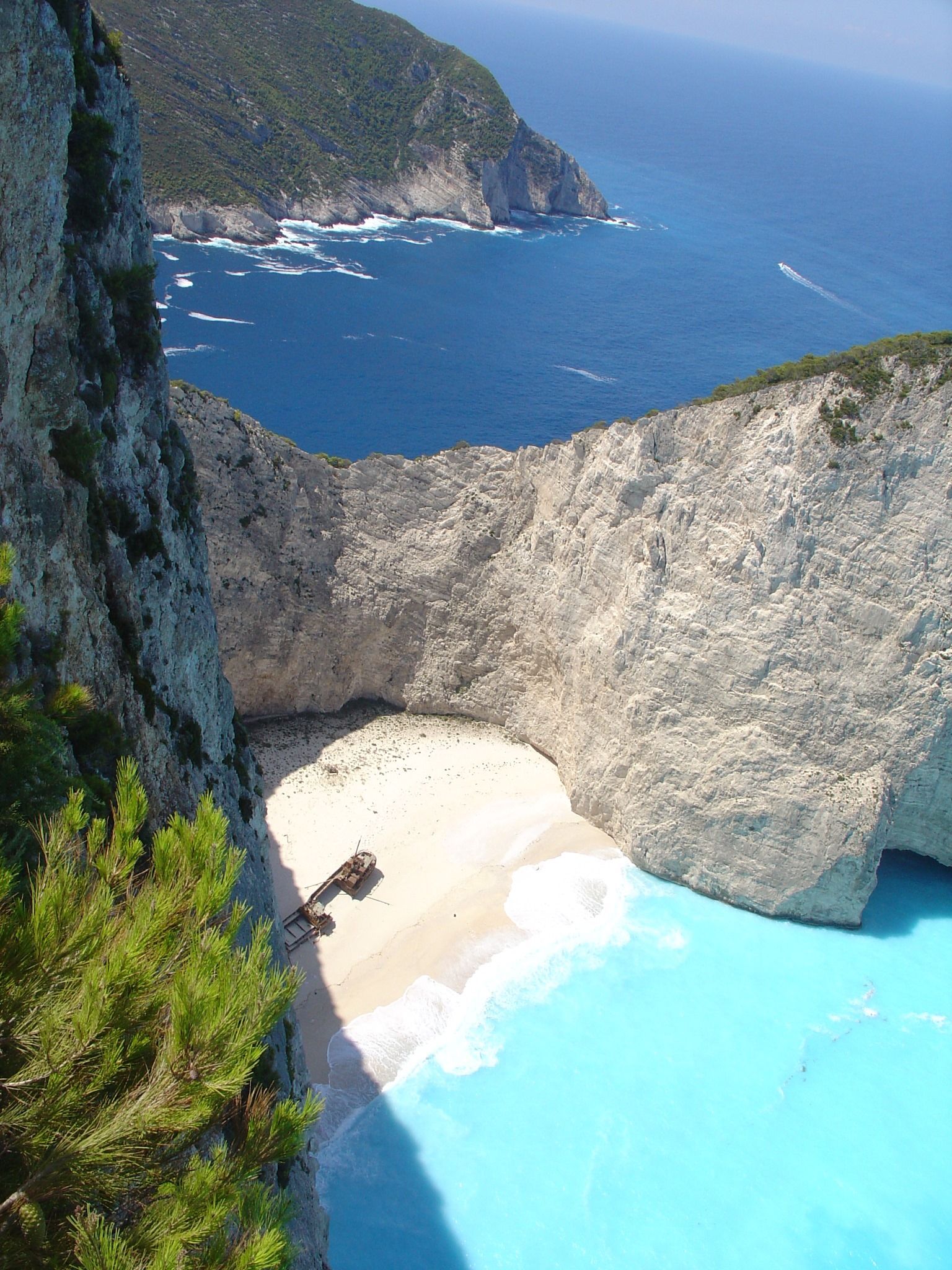 A view of a beach from a cliff overlooking the ocean